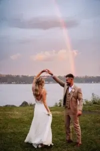 Des mariés dansent sous un arc-en-ciel à la Salle du Quai du Cap Blanc.