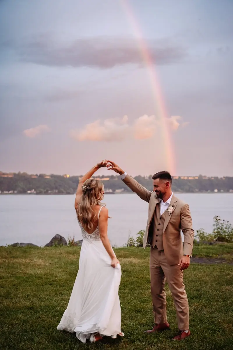 Des mariés dansent sous un arc-en-ciel à la Salle du Quai du Cap Blanc.