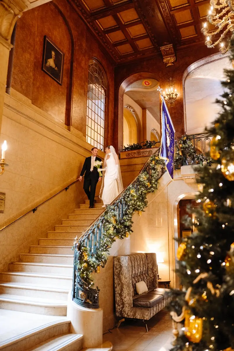 Bride and groom going down the grand staircase of the Fairmont Chateau Frontenac during Christmas