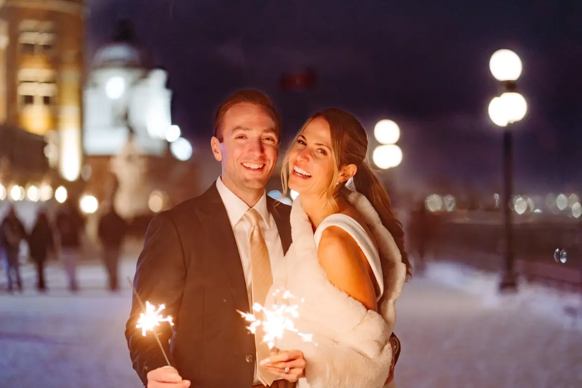 Bride and groom holding sparklers at night