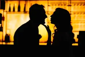 Silhouette d'une mariée et d'un marié devant un bar de l'Hotel Le Capitole