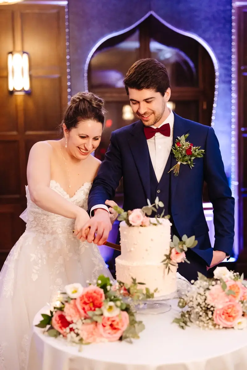 La mariée et le marié coupe leur gâteau de mariage dans la salle Place d'Armes du Chateau Frontenac.