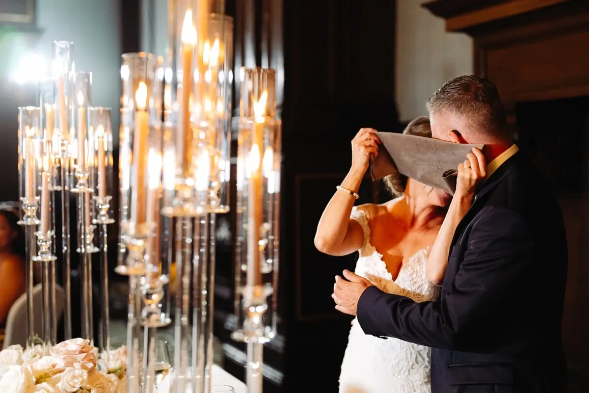 Des mariés qui se cachent derrière une serviette pour s'embrasser au Chateau de Quebec