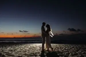 Silhouette d'un homme et une femme sur la plage au lever du soleil