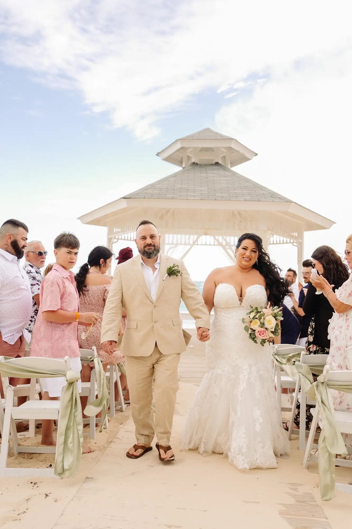 Les nouveaux mariés descendent l'allée lors de leur mariage au Bahia Principe Explore Punta Cana