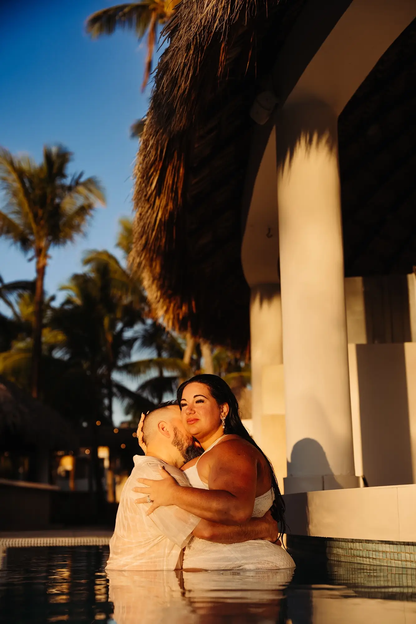 Un couple dans une piscine au lever du soleil au Bahia Principe Explore Punta Cana