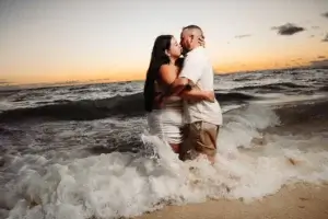 Un couple d'embrasse sur la plage du Bahia Principe Explore Punta Cana au lever du soleil