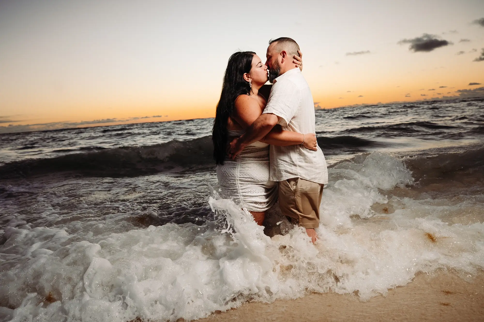 Un couple d'embrasse sur la plage du Bahia Principe Explore Punta Cana au lever du soleil