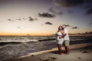 Un couple sur la plage au lever du soleil