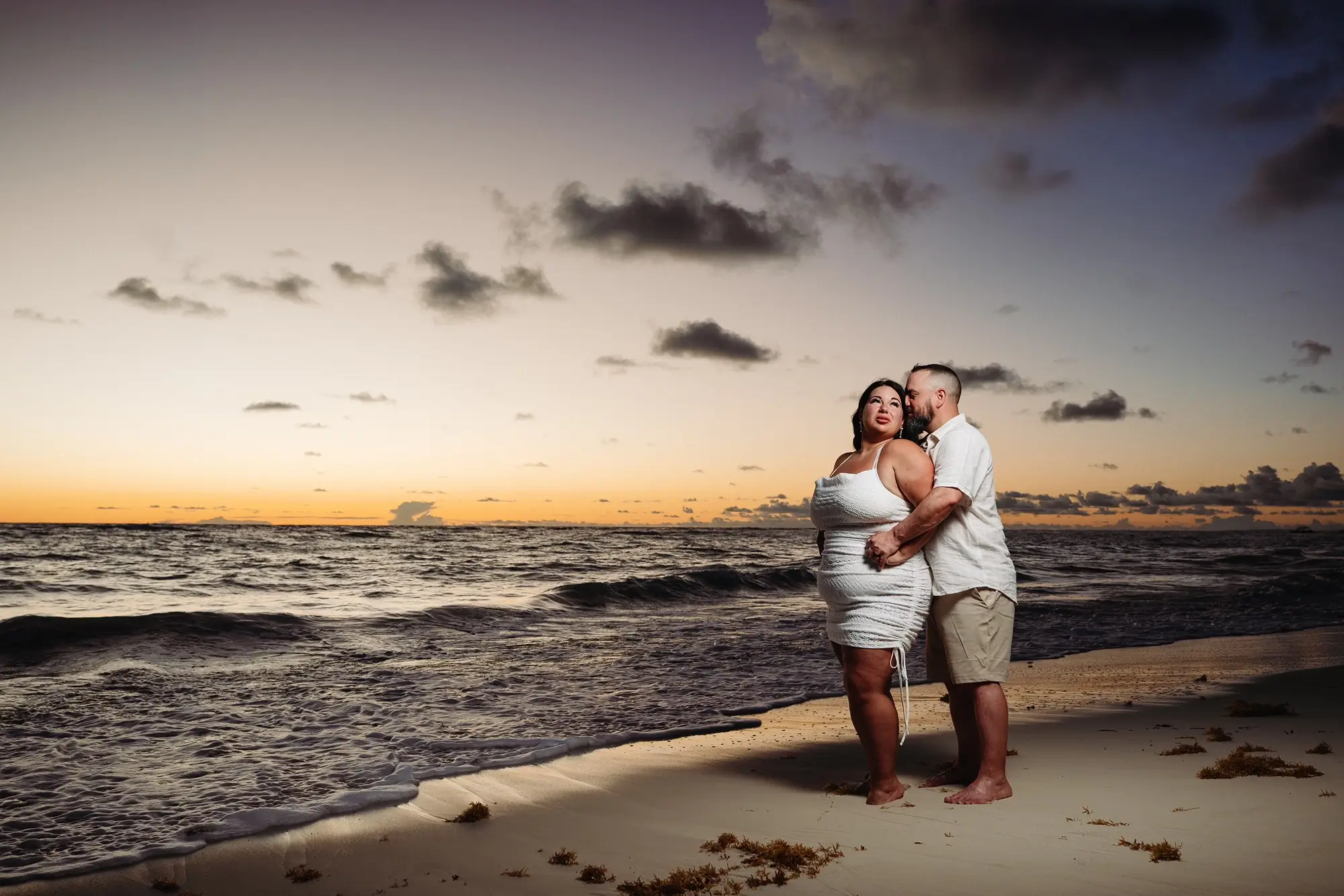 Un couple sur la plage au lever du soleil
