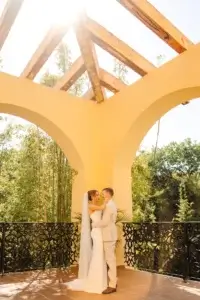 Un couple de mariés sur une terrasse avec un rayon de soleil