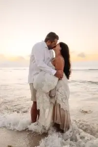 Un couple s'embrasse au lever du soleil sur la plage