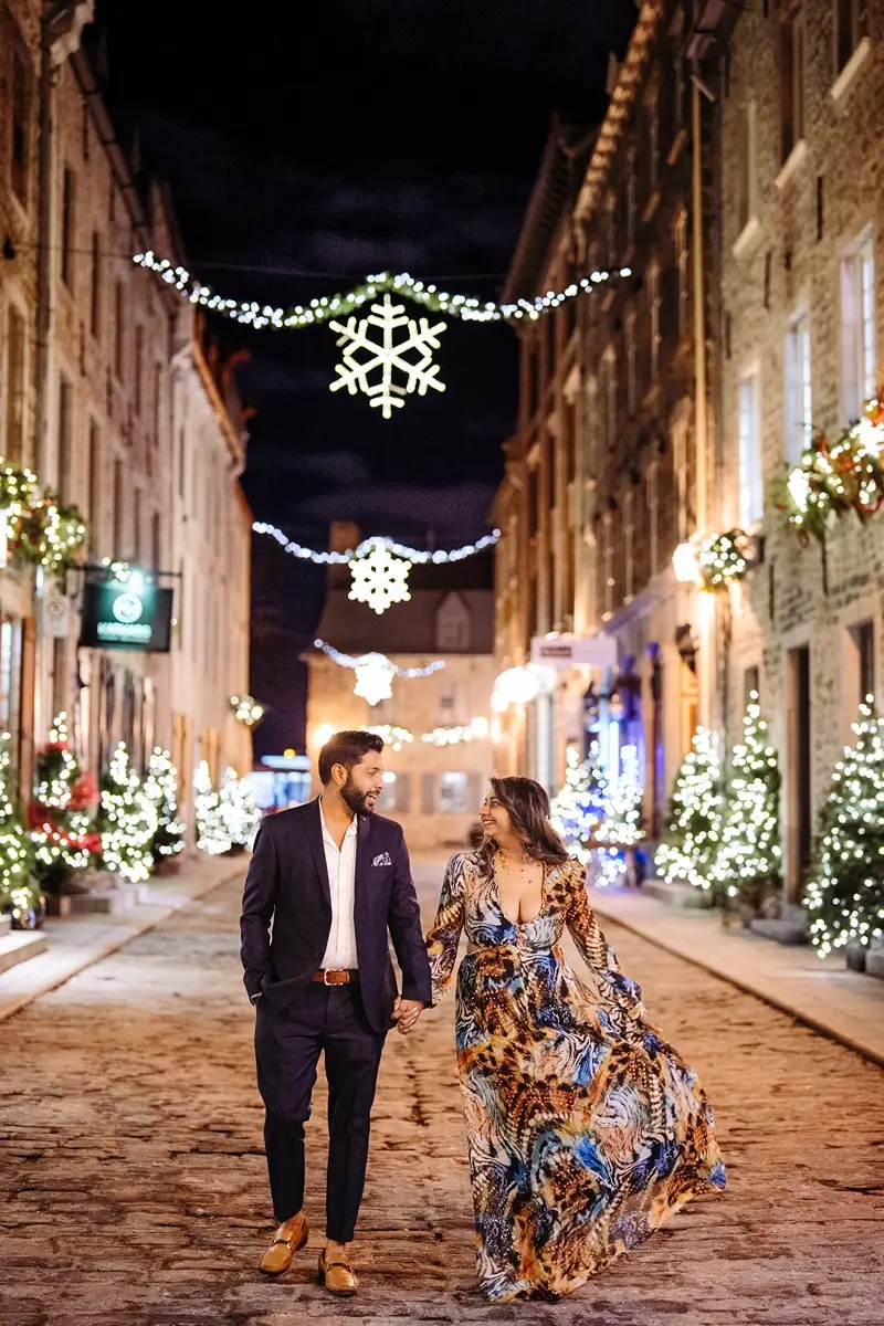Couple walking on cobblestones streets during Christmas