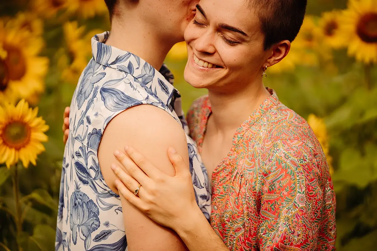 Sunflower field with LGBTQ+ lovers focus on the engagement ring