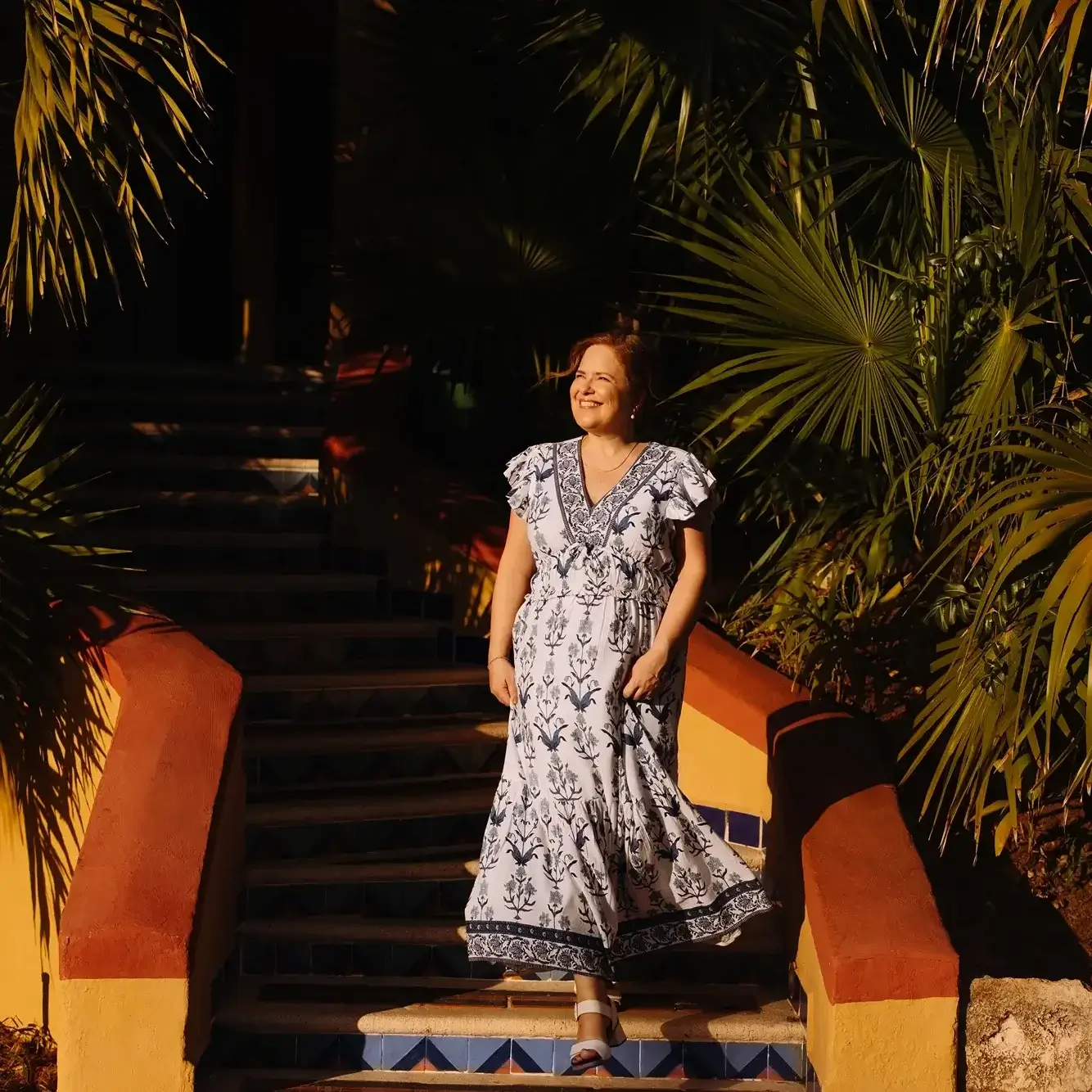 Une femme dans les escaliers de l'hotel Sandos Playacar au soleil