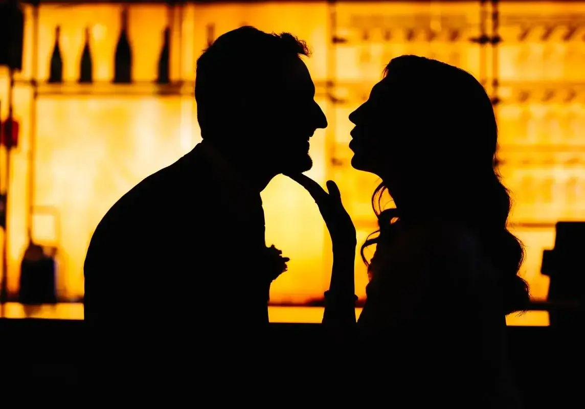 Silhouette d'une mariée et d'un marié devant un bar de l'Hotel Le Capitole